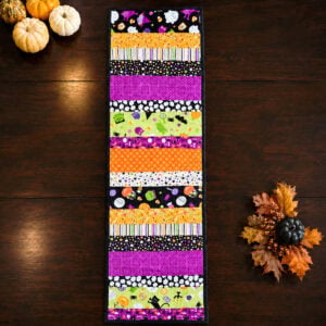 strip pieced quilted table runner for Halloween