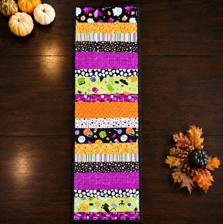 strip pieced quilted table runner for Halloween