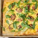 Easy Oktoberfest Pizza Recipe: Sausage, green apples gouda and arugula come together to make this delightfully delicious Pizza that your family will love!