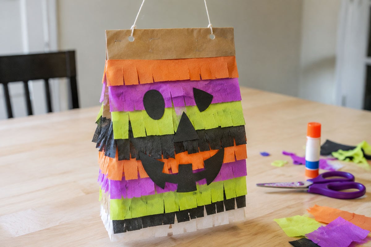 Halloween paper-bag piñata decorated with colorful tissue-paper fringe