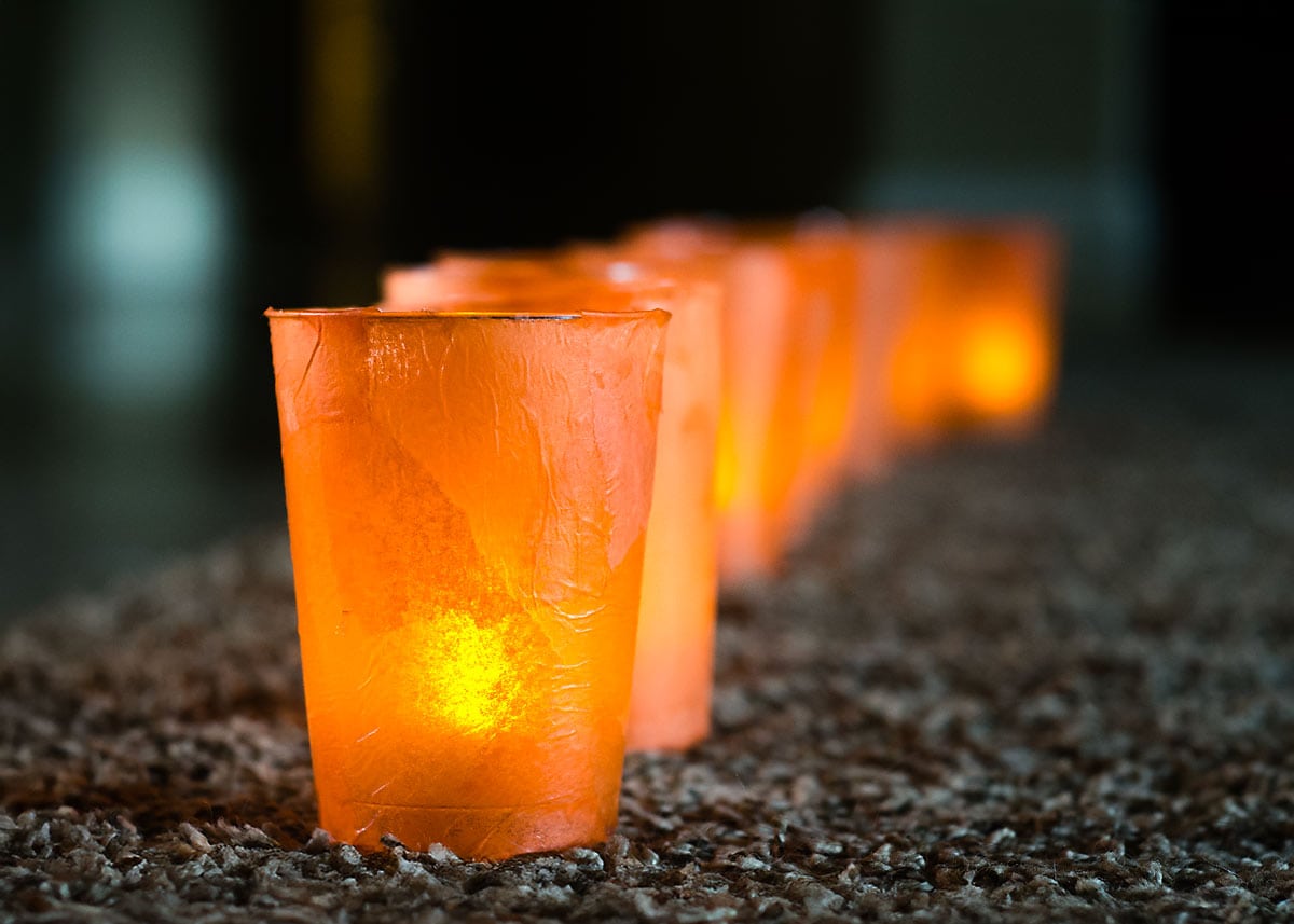 Glowing orange Halloween sidewalk lanterns made with plastic cups and tissue paper