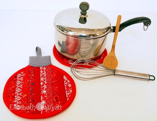 Round quilted Christmas ornament hot pad made from red, green, and white fabric strips