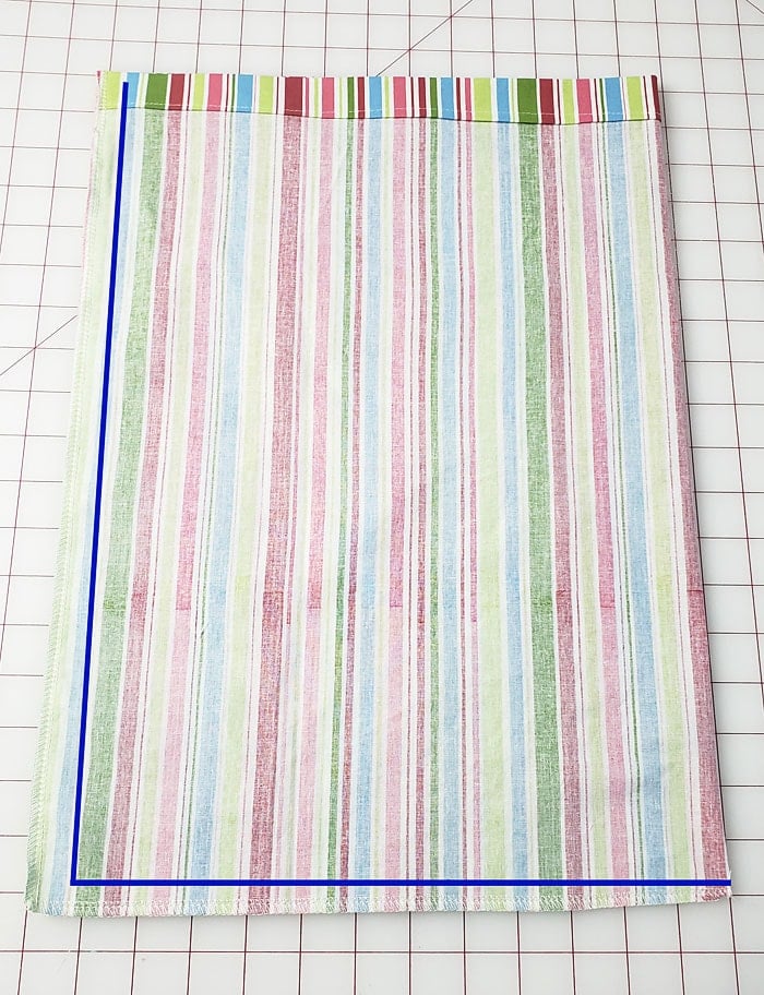 Fabric folded right sides together with a blue line indicating the side and bottom seams