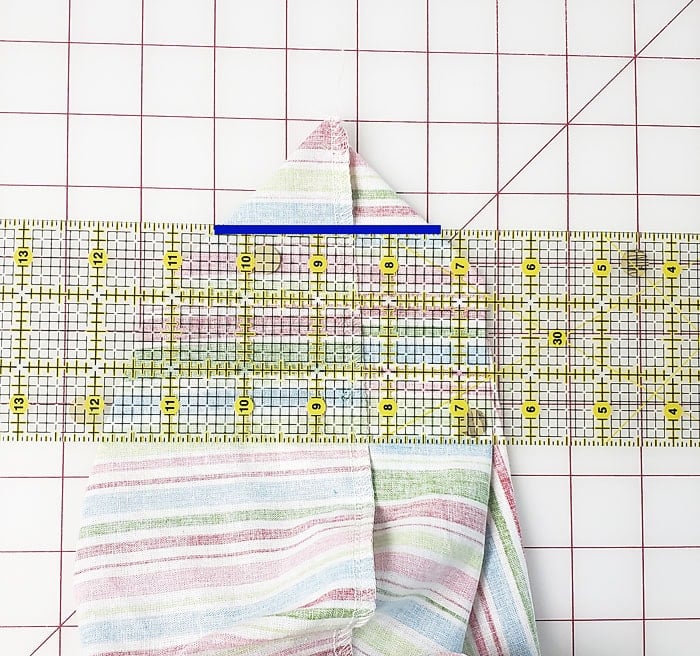 Ruler positioned across a flattened bottom corner with the stitching line marked
