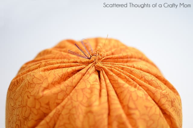 Gathering the top of a fabric pumpkin