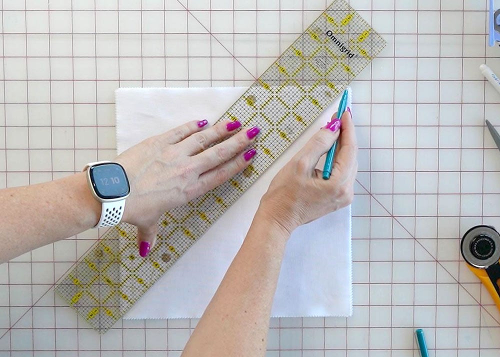 Drawing diagonal half-inch lines across stacked fabric squares