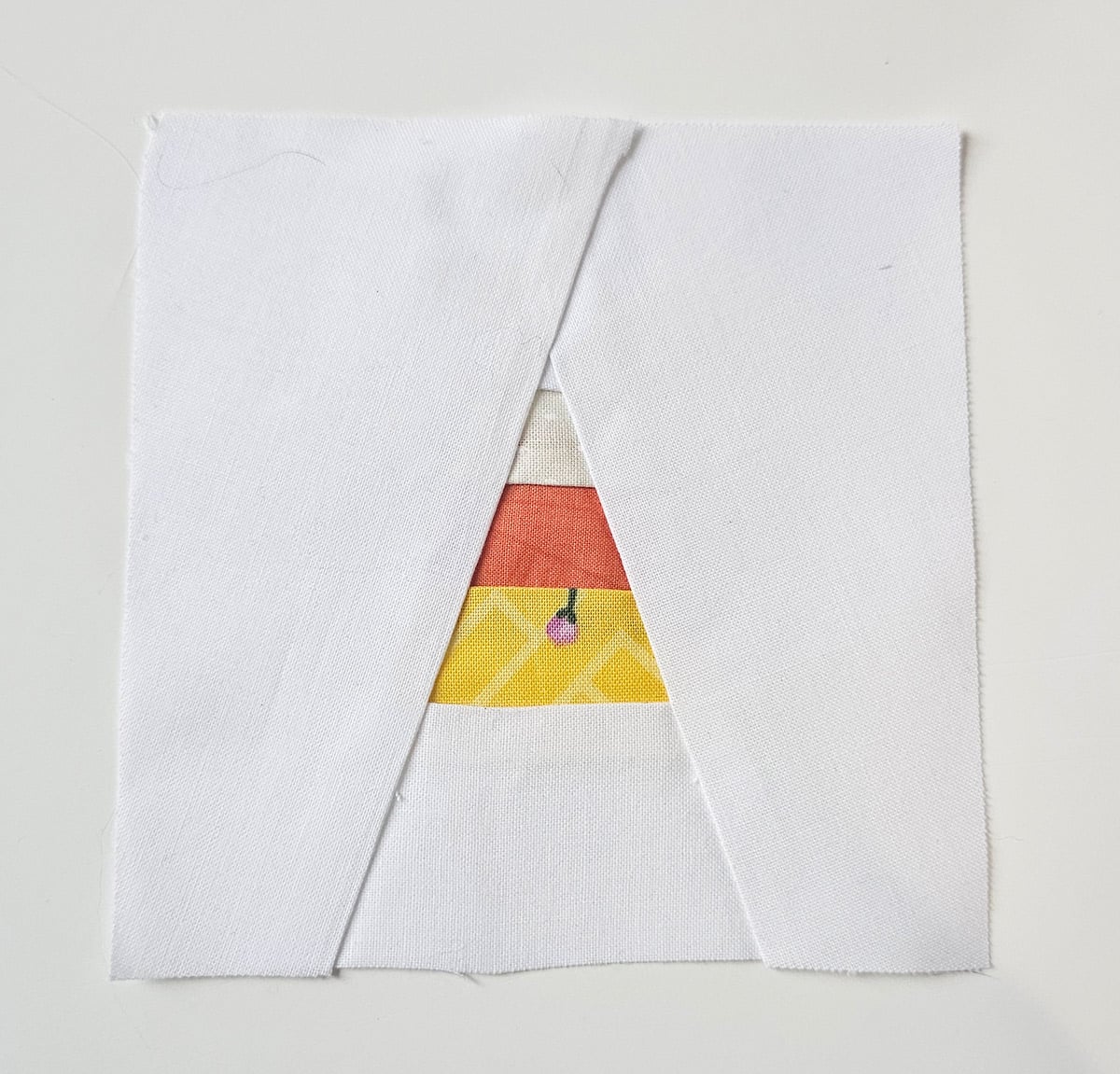 Completed mini candy corn quilt block with yellow white and orange fabric